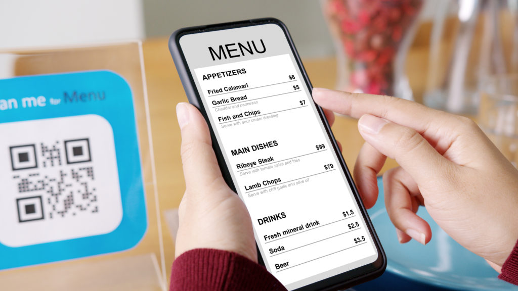 Hand's customer scan QR code for online menu service at table in restaurant during pandemic coronavirus. New normal contactless technology lifestyle protection coronavirus pandemic in restaurant